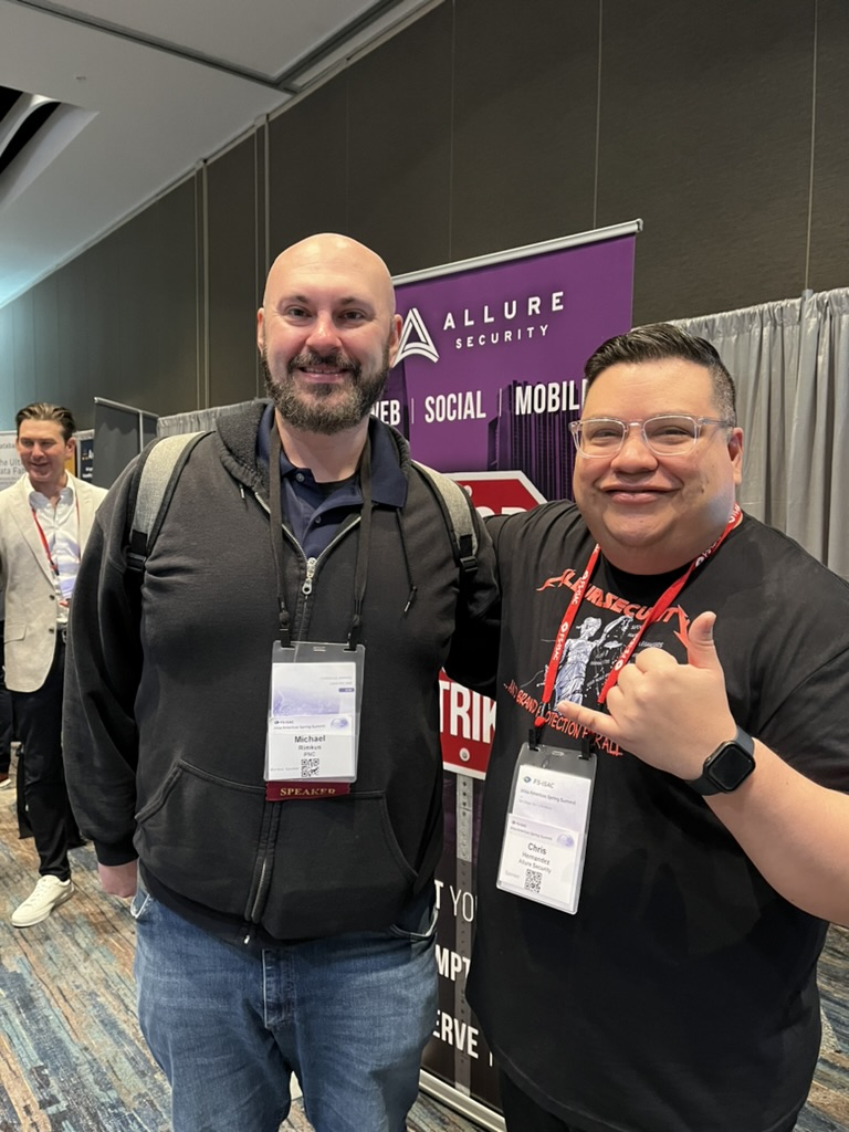 Chris at Allure Security conference booth with colleague